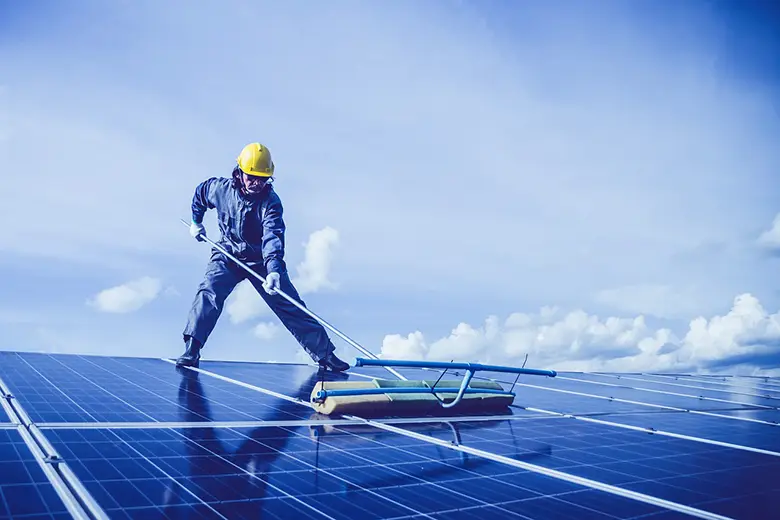 Hombre limpiando panel solar.